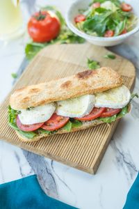 Healthiest Mendocino Farms Orders: Delicious Caprese sandwich with mozzarella, tomato, basil on wooden board.