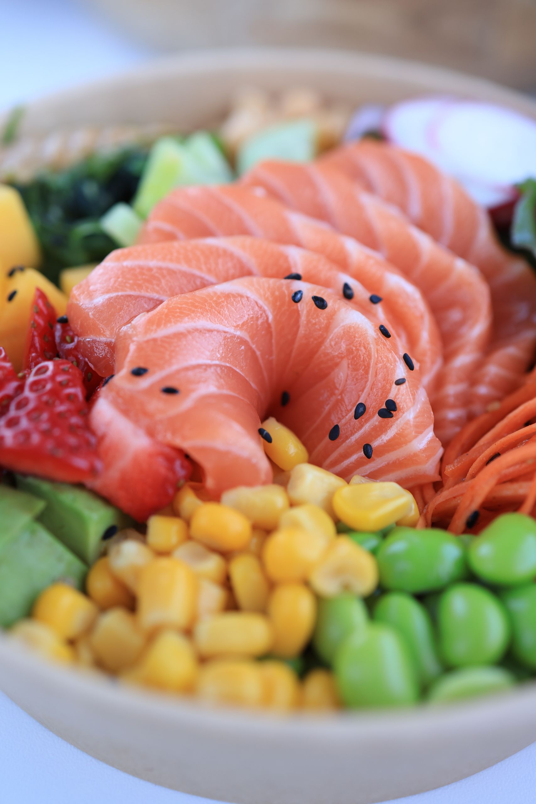 Best Foods for Muscle Gain: Delicious salmon poke bowl with fresh vegetables and fruits for a healthy meal.