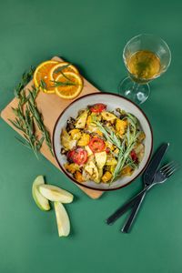what to eat on Ozempic as a vegetarian: Top view of a vibrant vegetable salad with citrus slices on a green background.