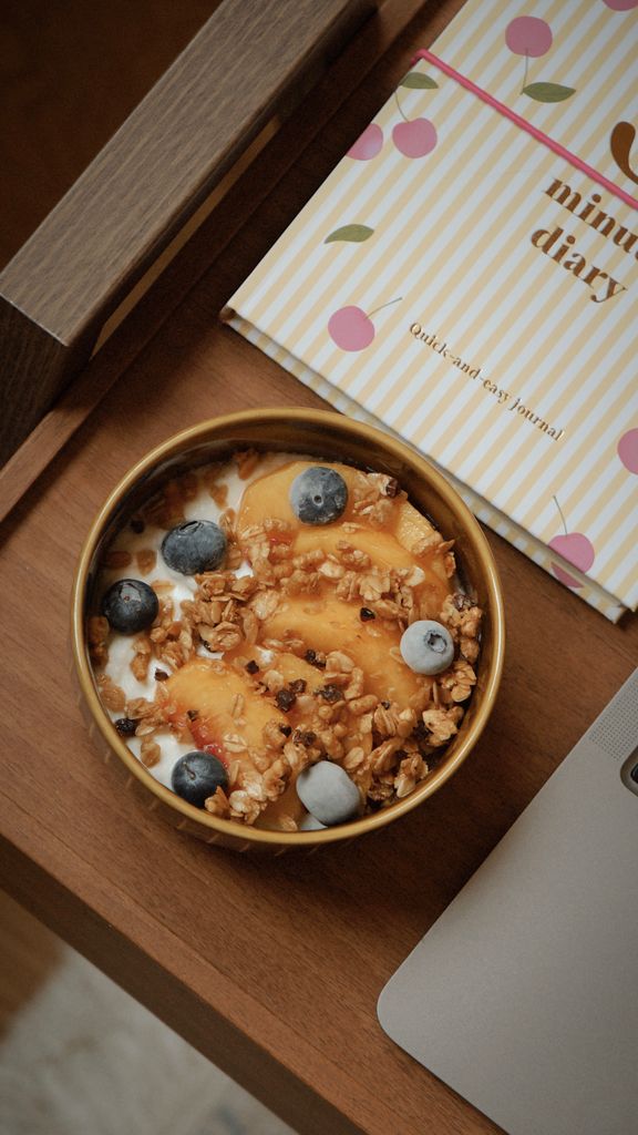mindful eating tips: A delicious yogurt bowl with peaches, blueberries, and granola, perfect for a healthy snack or breakfast.