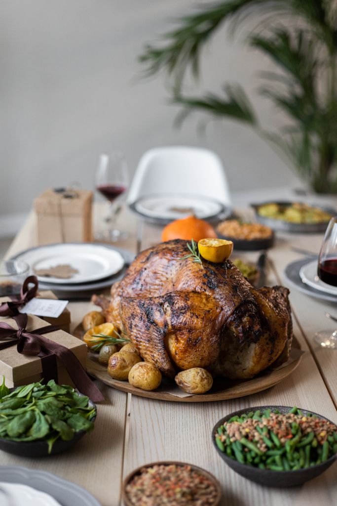 Thanksgiving Healthy Eating Tips: From above of roasted turkey and gift boxes on wooden table served for celebrating Thanksgiving Day