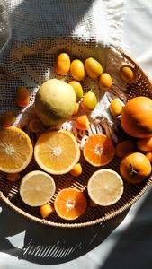 Most Common Nutrient Deficiencies in Women: Vibrant citrus fruits in a wicker basket with woven cloth, captured in warm natural light.
